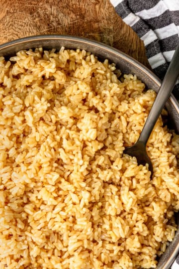 instant pot brown rice recipe in a gray bowl with a black serving spoon