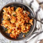 parmesan roasted cauliflower recipe in a gray ceramic bowl with a black serving fork