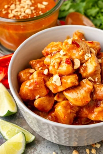easy peanut butter chicken recipe in a bowl topped with chopped unsalted roasted peanuts