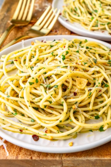 olive oil pasta recipe on a white plate with a gold fork