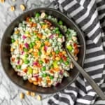 pea salad recipe with bacon and peanuts in a black bowl with a black spoon