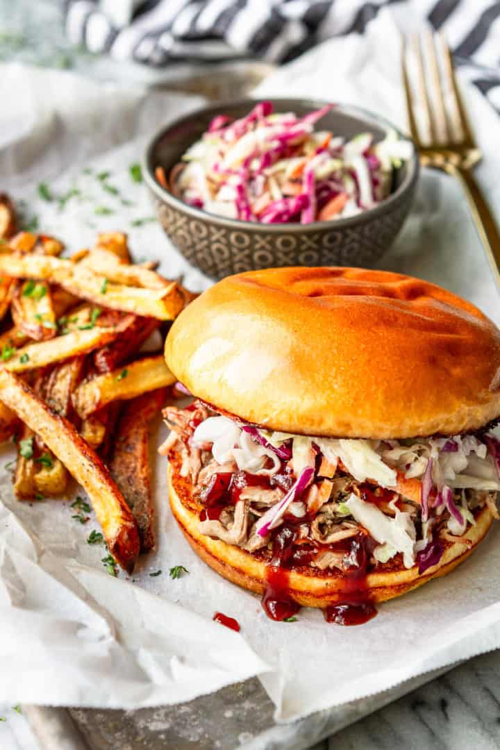 Dr Pepper pulled pork sandwich topped with Southern style coleslaw and a side of crispy oven fries