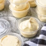 rumchata pudding shots in plastic shot cups with lids with a black and white kitchen towel