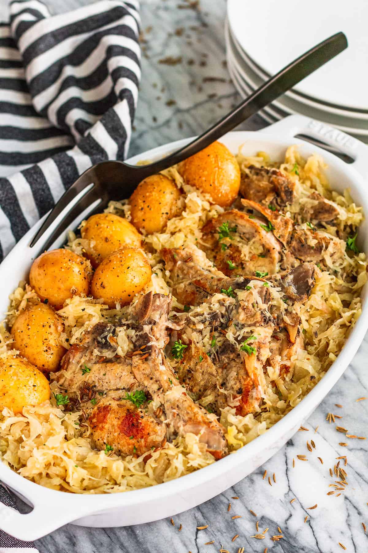 easy slow cooker pork chops and sauerkraut with baby yellow potatoes and a sprinkle of caraway seed