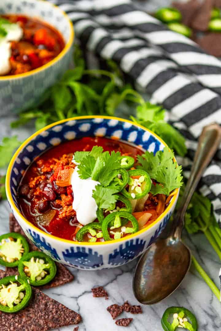 instant pot turkey chili garnished with sour cream, cilantro, and sliced jalapeno peppers