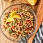 chickpea tuna salad recipe in a glass bowl on a wooden cutting board with lemon garnish
