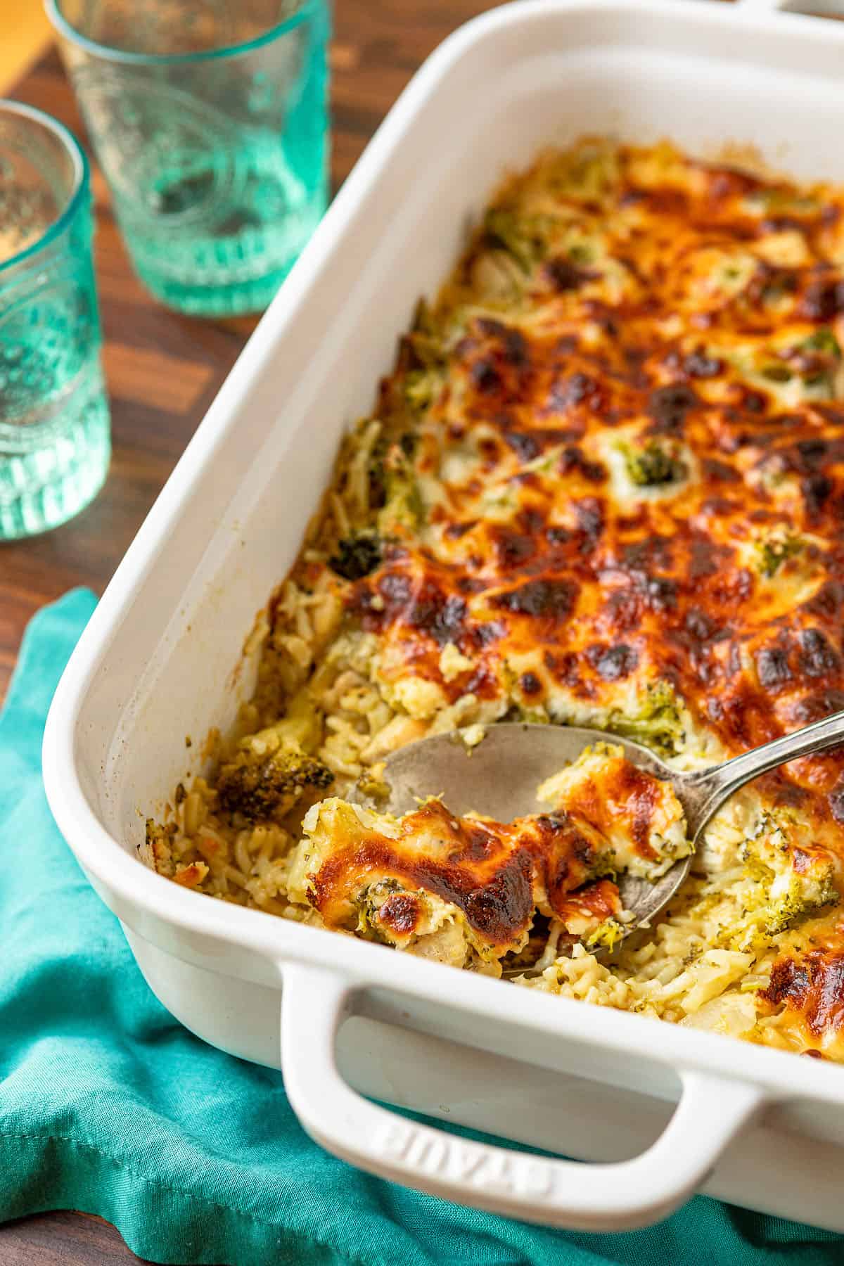 broccoli rice cheese and chicken casserole being served with a silver serving spoon