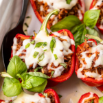 italian stuffed peppers recipe made in a ceramic casserole dish with a basil garnish