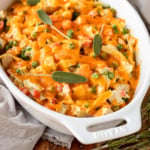 turkey noodle casserole recipe garnished with fresh sage in a white casserole dish