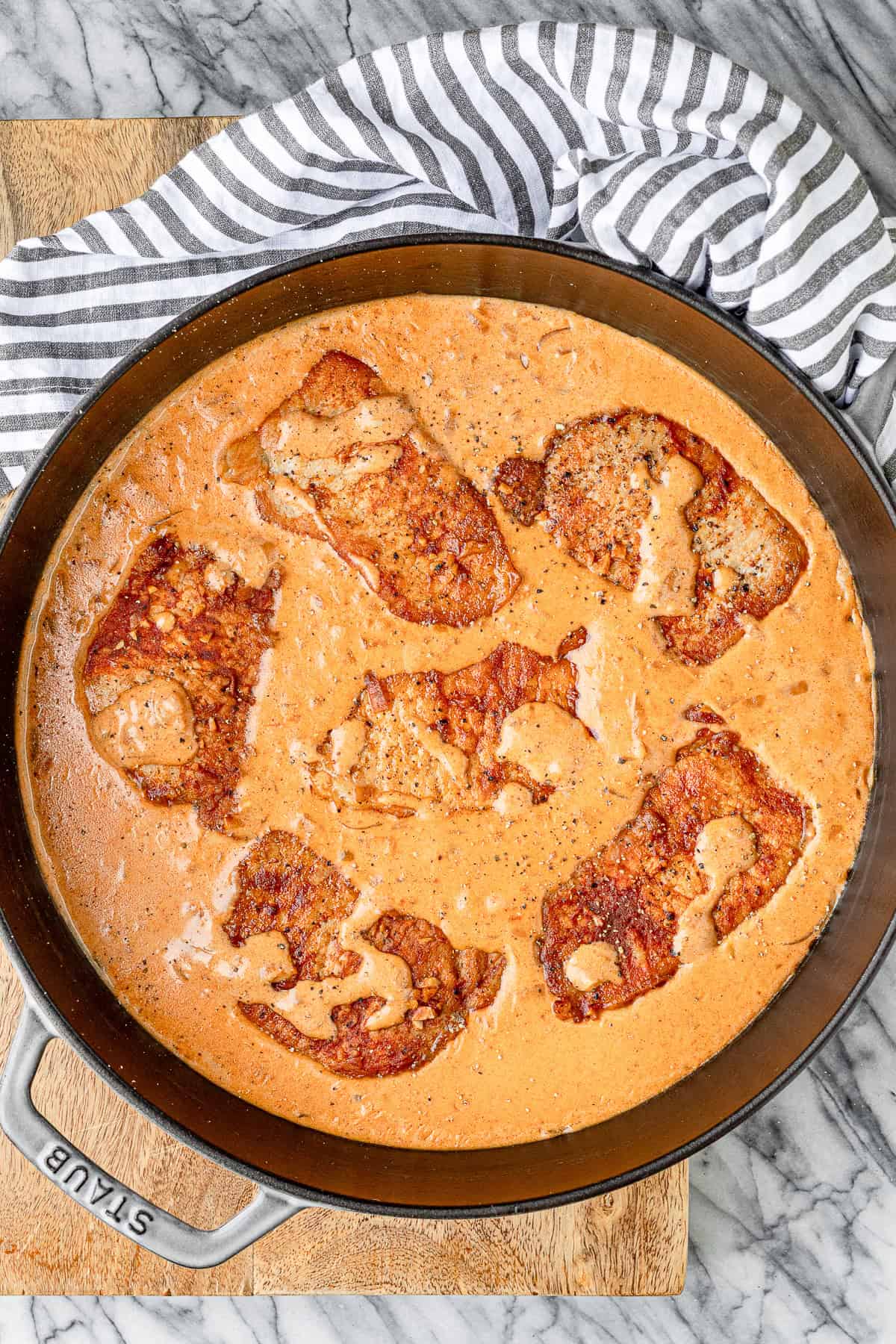 paprika pork chops in a sour cream gravy with a striped napkin