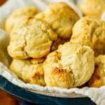 cream biscuits in a wooden bowl lined with a white towel