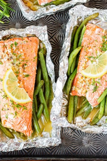 two salmon grilled in foil with green beans and fresh dill