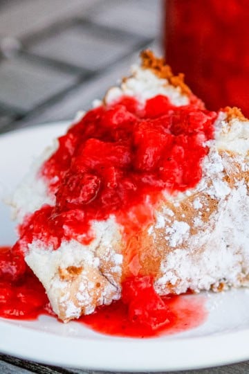 strawberry sauce over angel food cake dusted with powdered sugar
