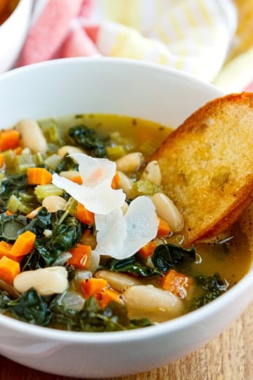 ceramic bowl of tuscan bean soup with kale