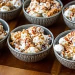 grape salad with cream cheese in individual gray ceramic bowls topped with brown sugar and toasted pecans