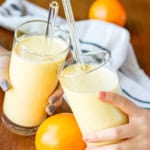 two glasses filled with orange mango citrus smoothie