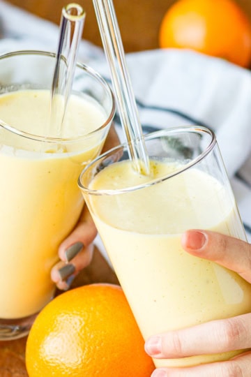 two glasses filled with orange mango citrus smoothie