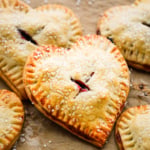 cherry hand pies sprinkled with sugar on brown parchment paper
