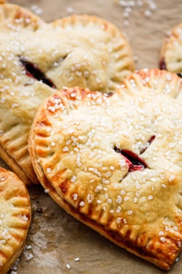 cherry hand pies sprinkled with raw cane sugar on brown parchment paper
