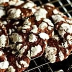 chocolate crinkles stacked up on a wire cooling rack
