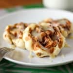 easy cinnamon roll waffles on a plate drizzled with cream cheese glaze