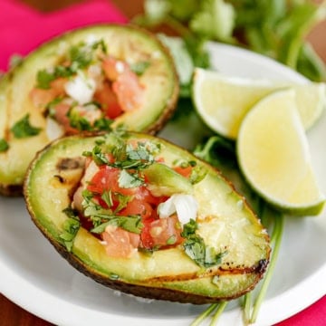 grilled avocado with pico de gallo on a white ceramic dish
