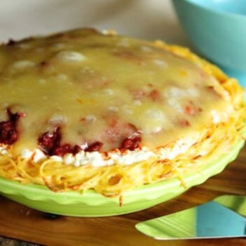 spaghetti pie with cottage cheese in a lime green pie dish