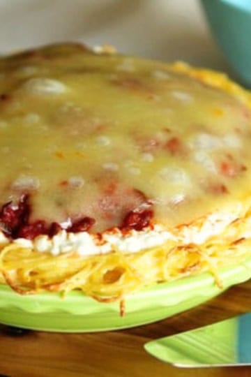 spaghetti pie with cottage cheese in a lime green pie dish