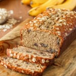 oatmeal banana bread sliced on a wooden cutting board