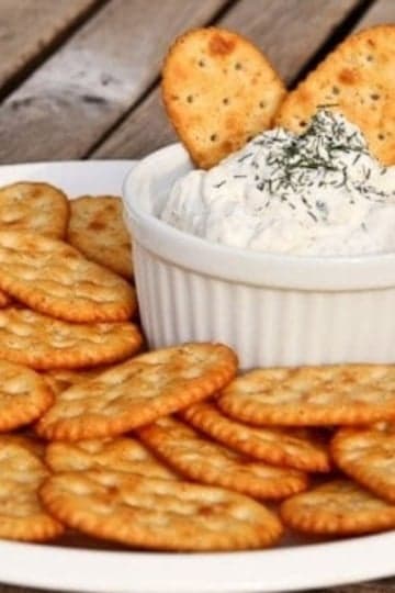 dill dip in a bowl with crackers around it