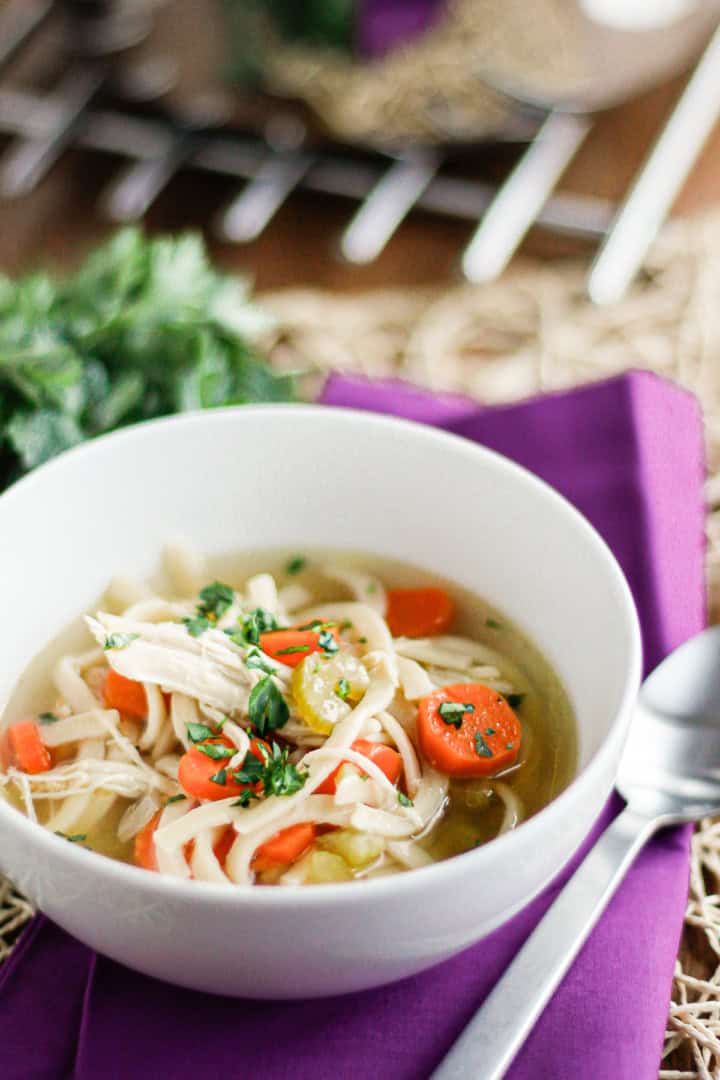 chicken soup with celery and carrots in a white bowl